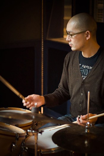 Photo of Bernie Arai playing drum kit
